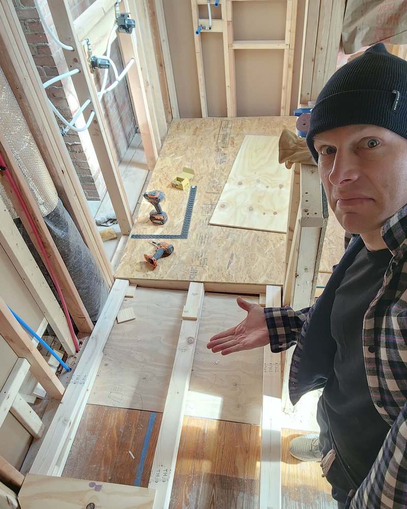 Jared on a framing job, gesturing at a subfloor